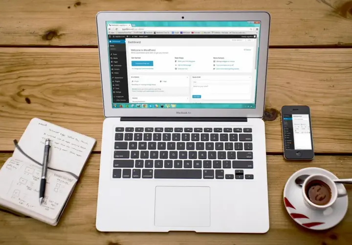 Na laptopie widać panel WordPress, obok smartfon i notatnik. To idealne miejsce do nauki, jak zainstalować WordPress na XAMPP.